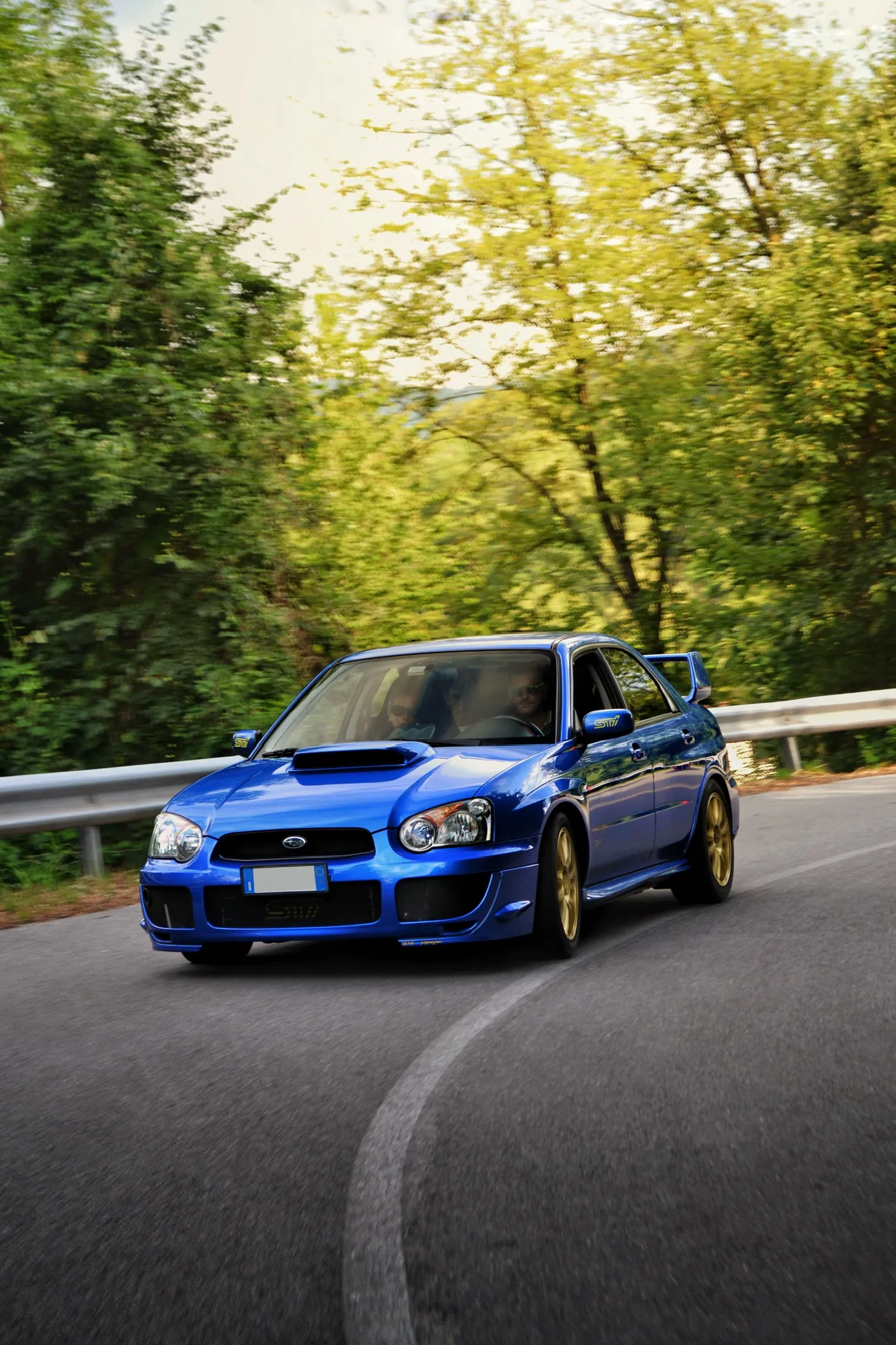 Blue Subaru Impreza on a winding mountain road