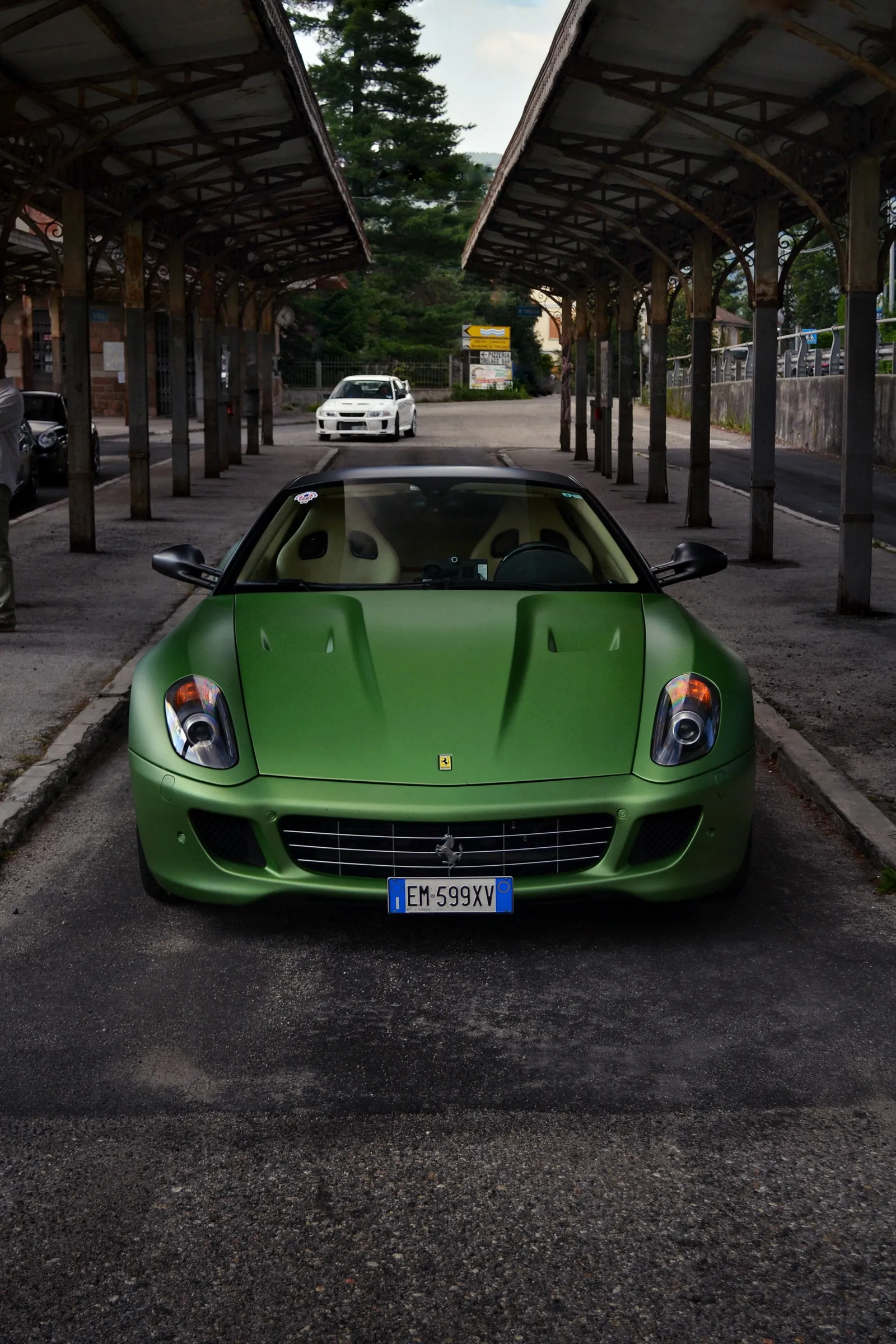 Green Ferrari seen from the front under an old railway canopy