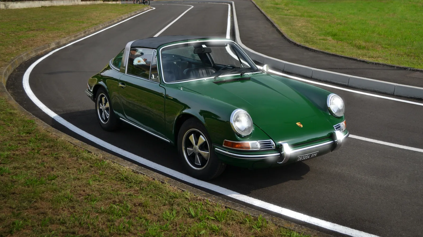 Green classic Porsche 911 Targa on a winding track